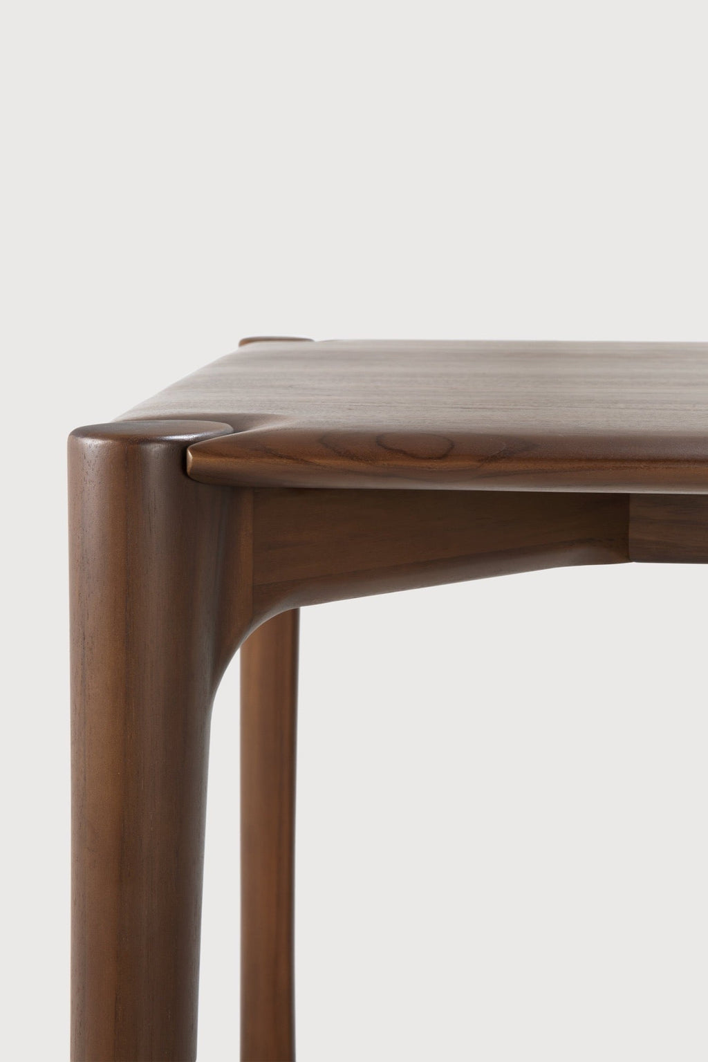 PI Dining Table in dark teak with sculpted base and curved edges, handcrafted from solid natural teak