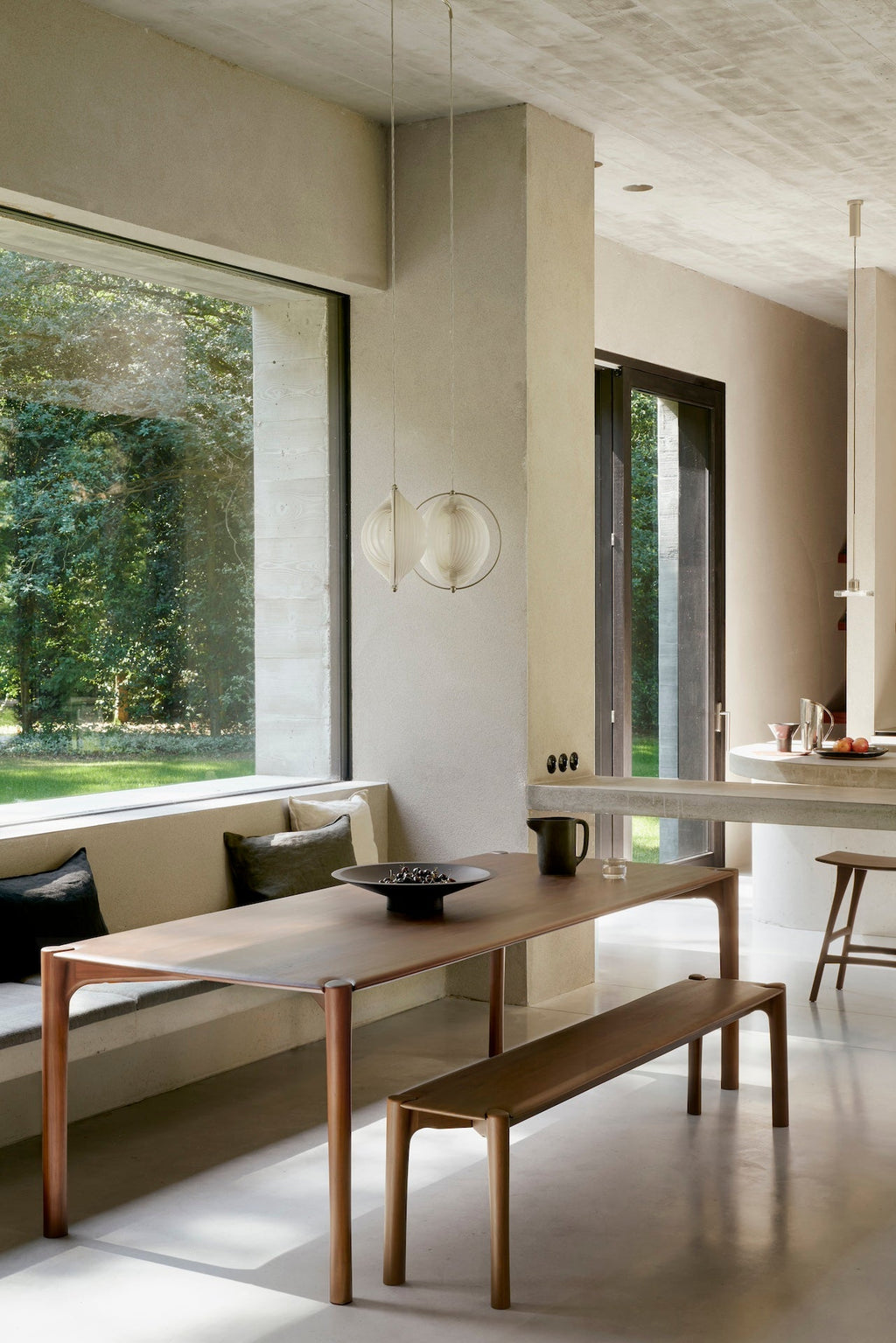 Dark teak PI dining table with sculpted base and curved edges, handcrafted from solid natural teak