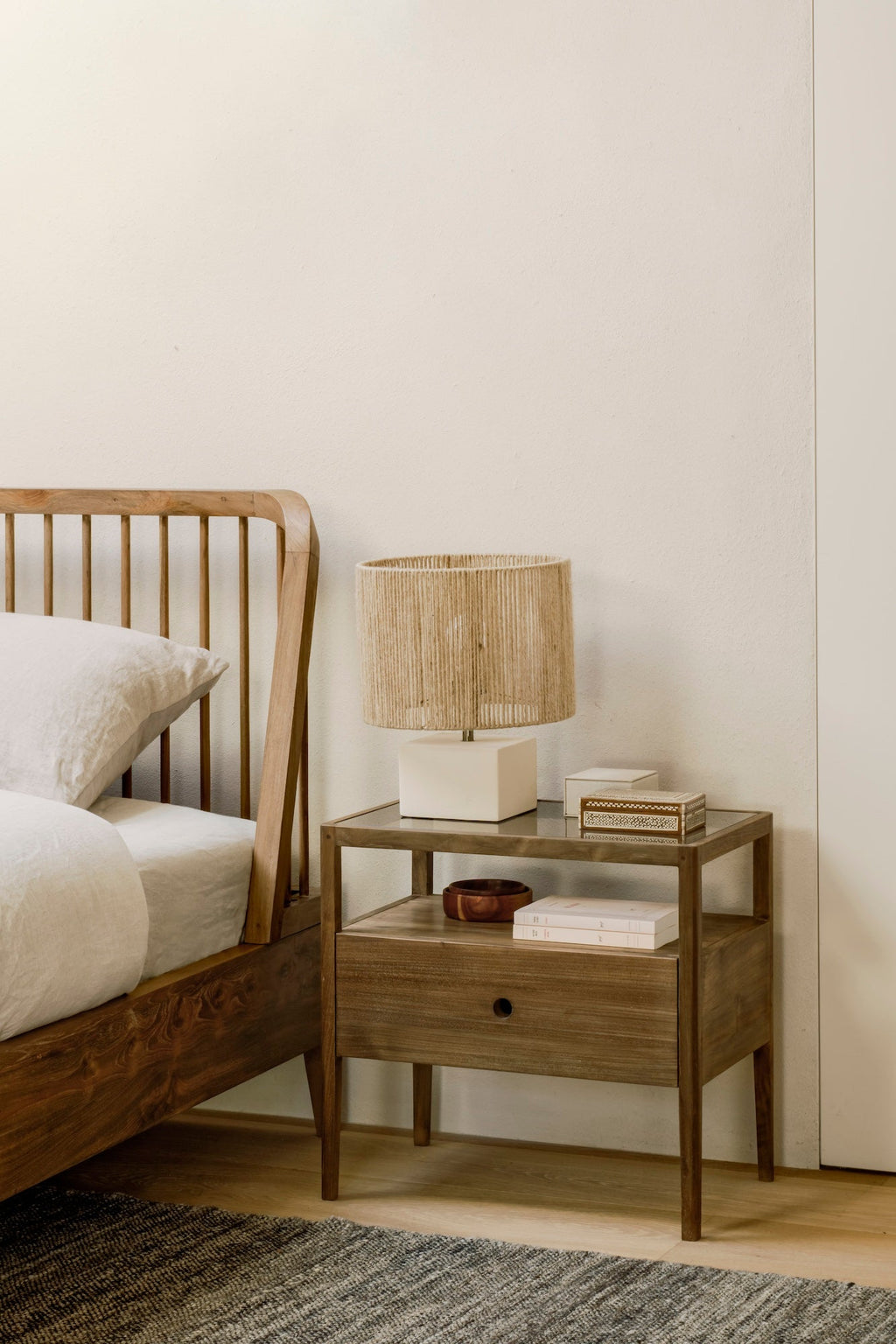 Spindle Bedside Table in dark teak with glass top, open shelf, and minimal drawer design