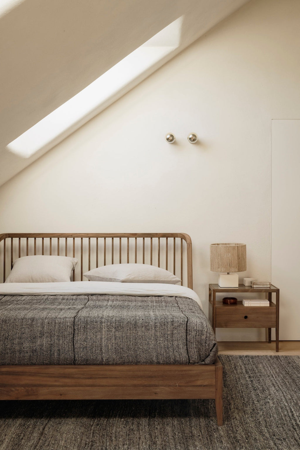 Dark teak spindle bed with curved edges and classic headboard design made from European white oak