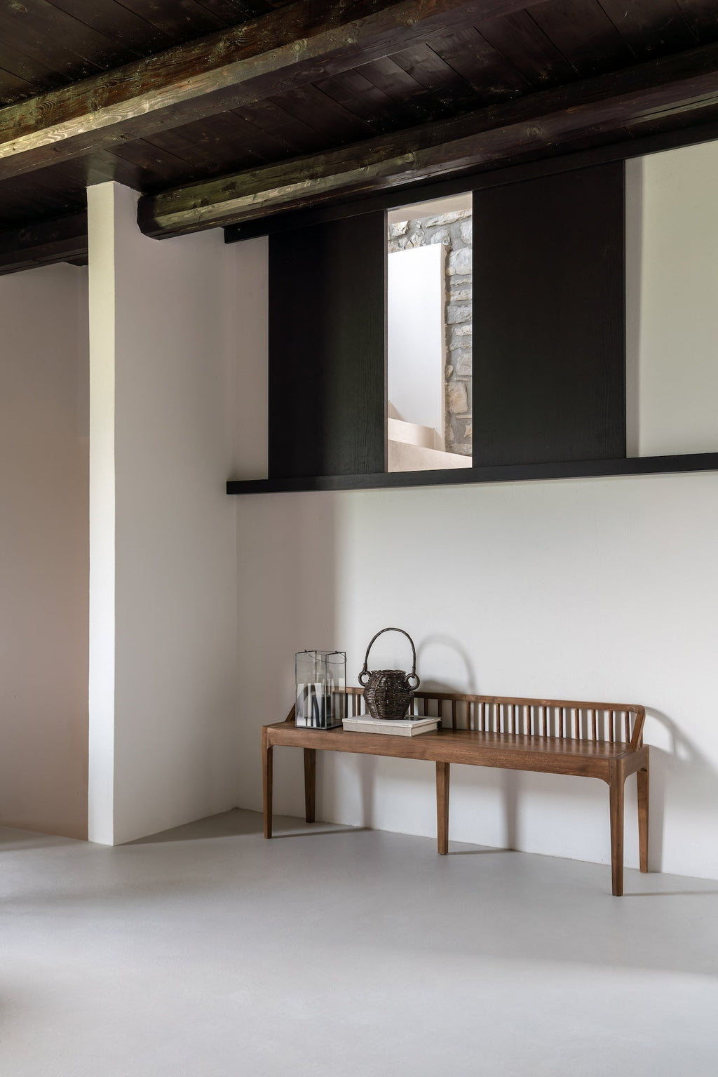 Dark teak spindle bench with low spoked back and spacious seat in European white oak, coastal modern style