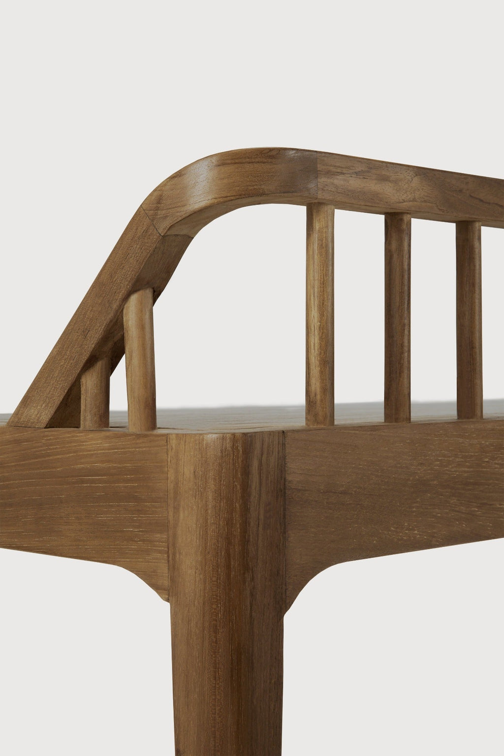 Dark teak spindle bench with low spoked back and spacious seat in coastal modern style