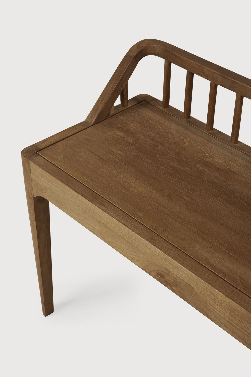 Dark teak spindle bench with low spoked back and spacious seat in coastal modern style