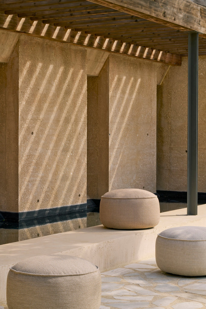Concrete pillars and seating area with outdoor poufs. 