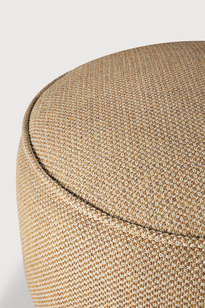 Close-up of a textured beige ottoman on a light gray background