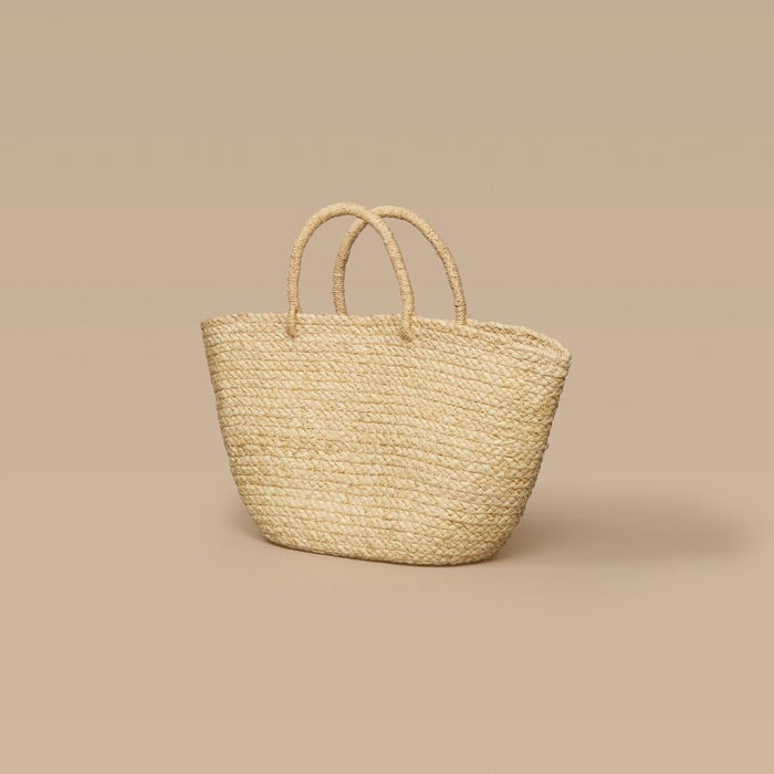 Woven raffia bag on a beige background