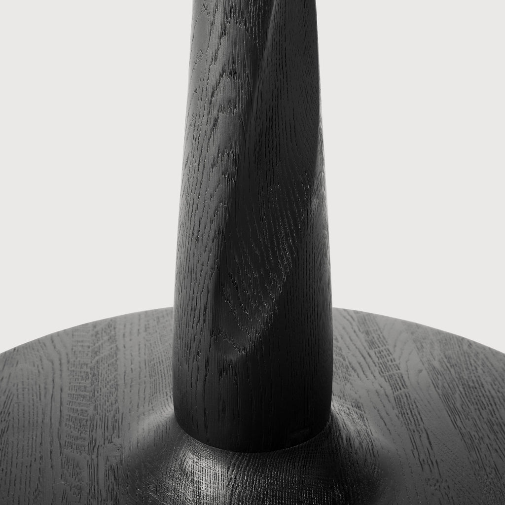 Black Oak Torsion Dining Table detail with white background and a beautiful sculpted wood base. - Saffron and Poe, Ethnicraft