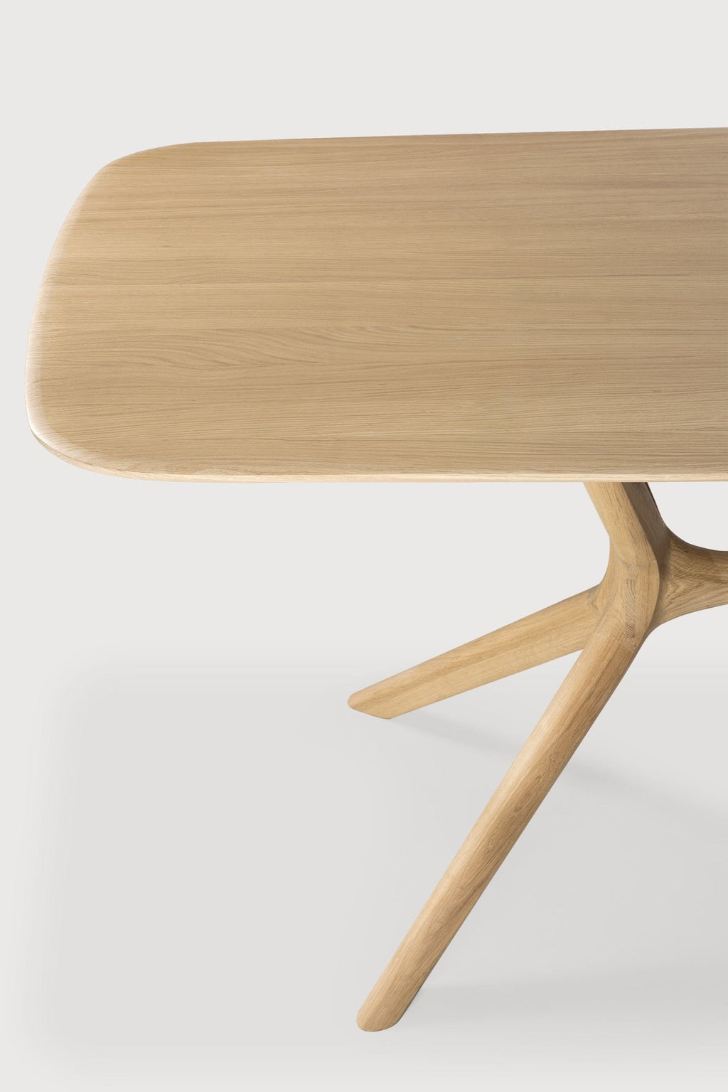 White oak X Dining Table with contoured base and smooth tabletop in modern dining room