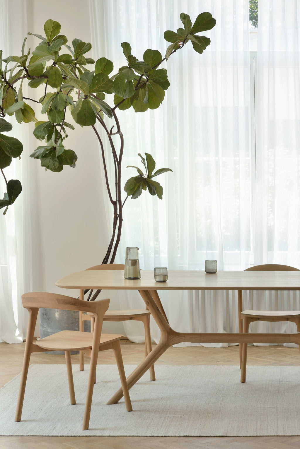 X Dining Table in white oak with seamless contoured base and oiled finish