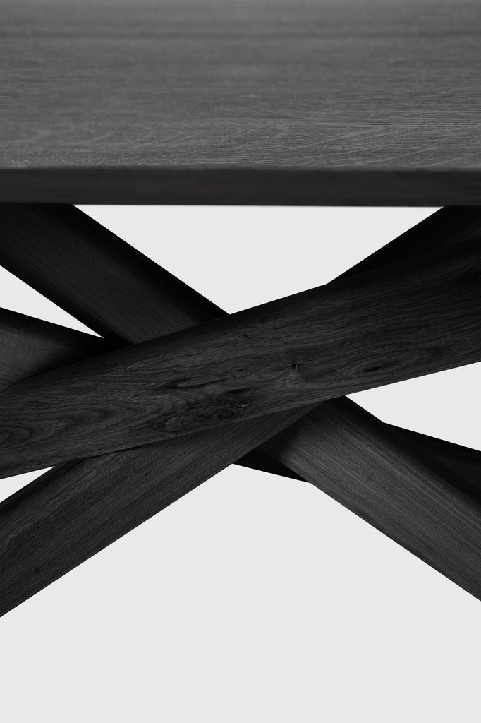 Black Oak Oval Mikado Dining Table detail with white background and beautiful intersecting wood legs. - Saffron and Poe, Ethnicraft