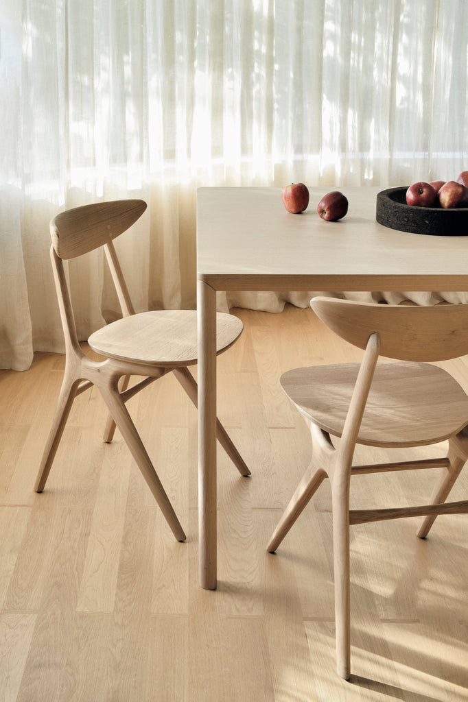 White Oak Air Dining table and White Oak Bok Dining Chairs in modern bright dining room with sheer curtains and oak floors. - Saffron and Poe, Ethnicraft