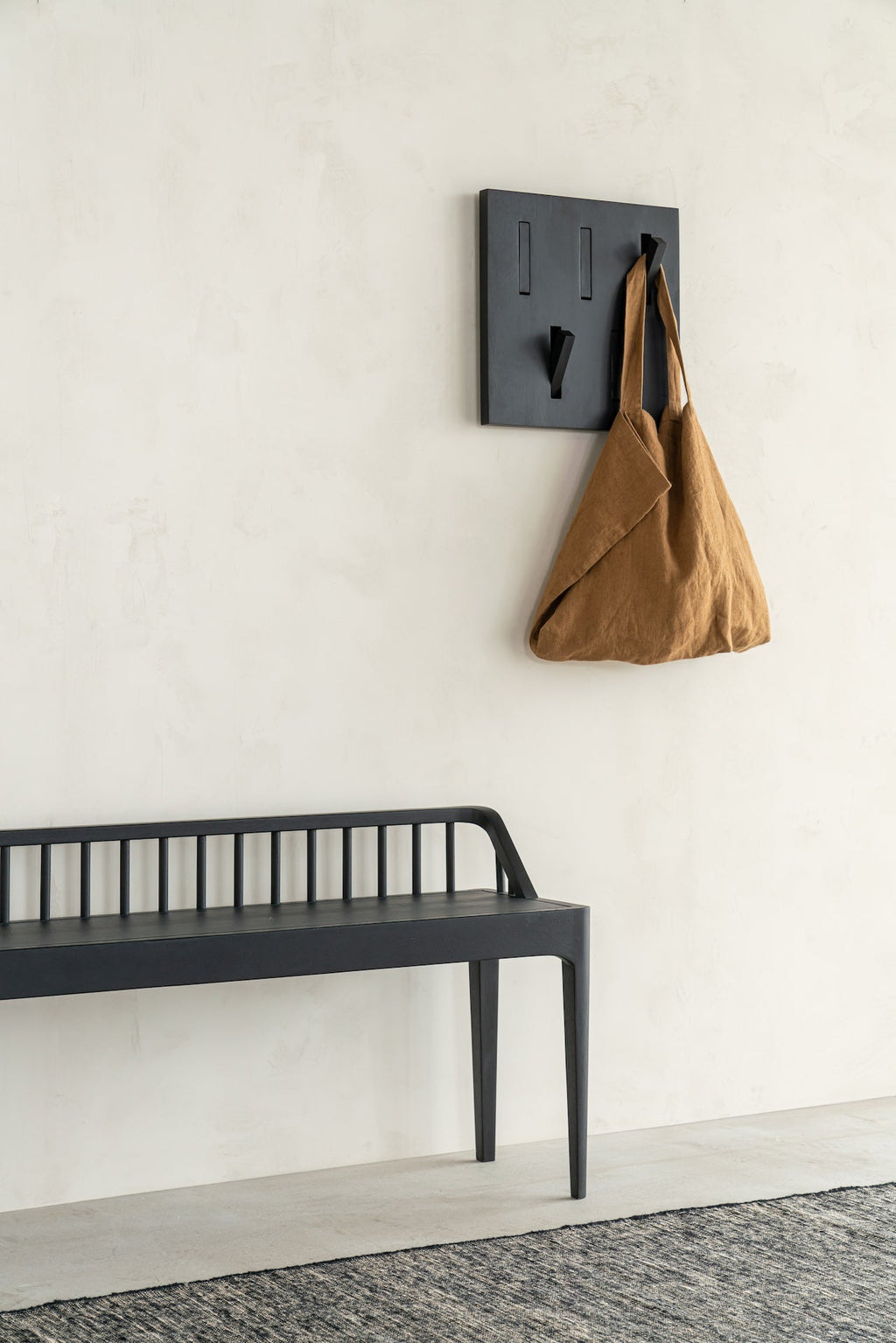 Black oak spindle bench with low spoked back and spacious seat in coastal modern style