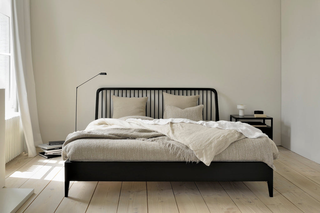 Black oak spindle bed with classic headboard and curved edges in coastal modern style