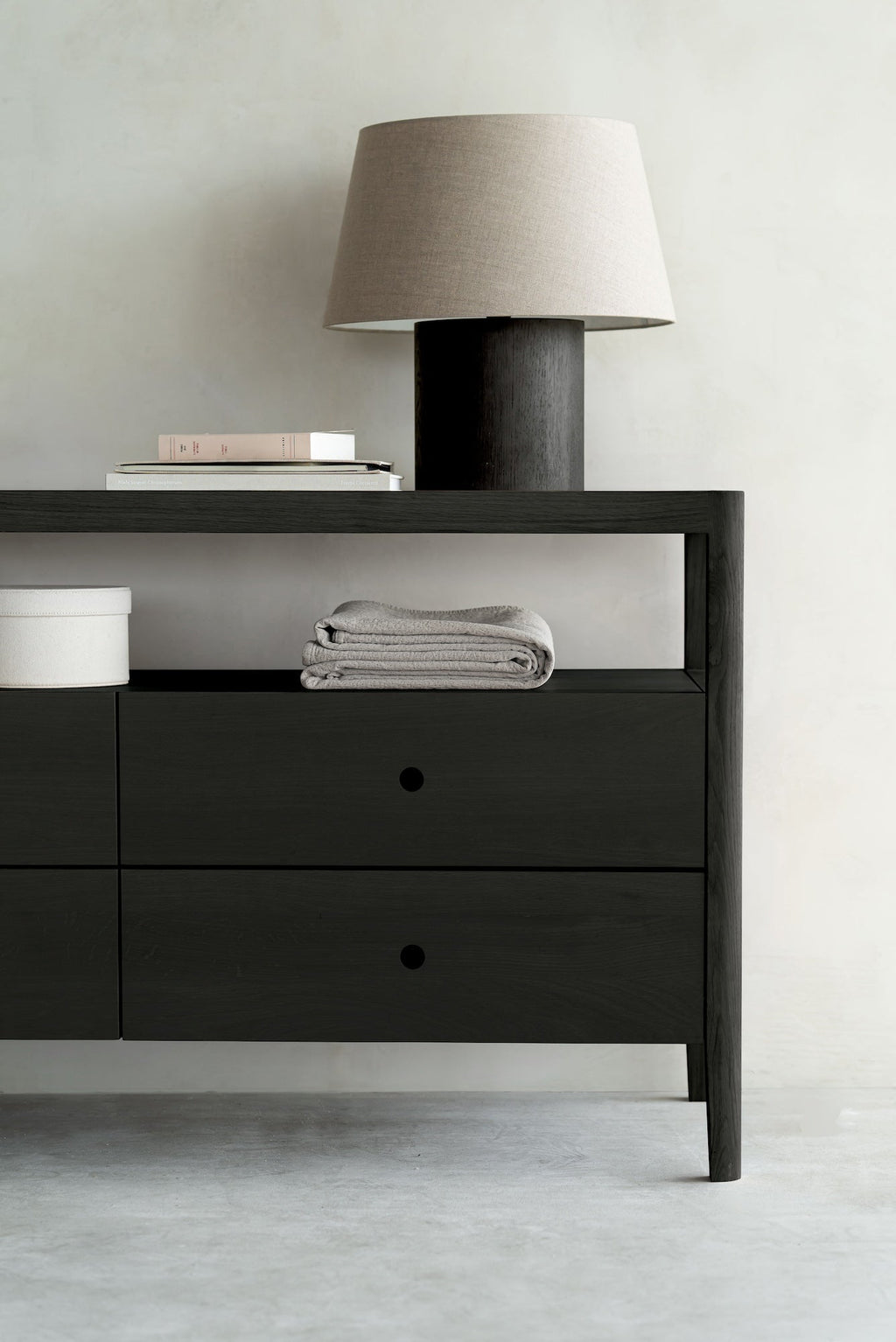 Black oak Spindle Dresser with four drawers, open shelf, and glass top in coastal modern style