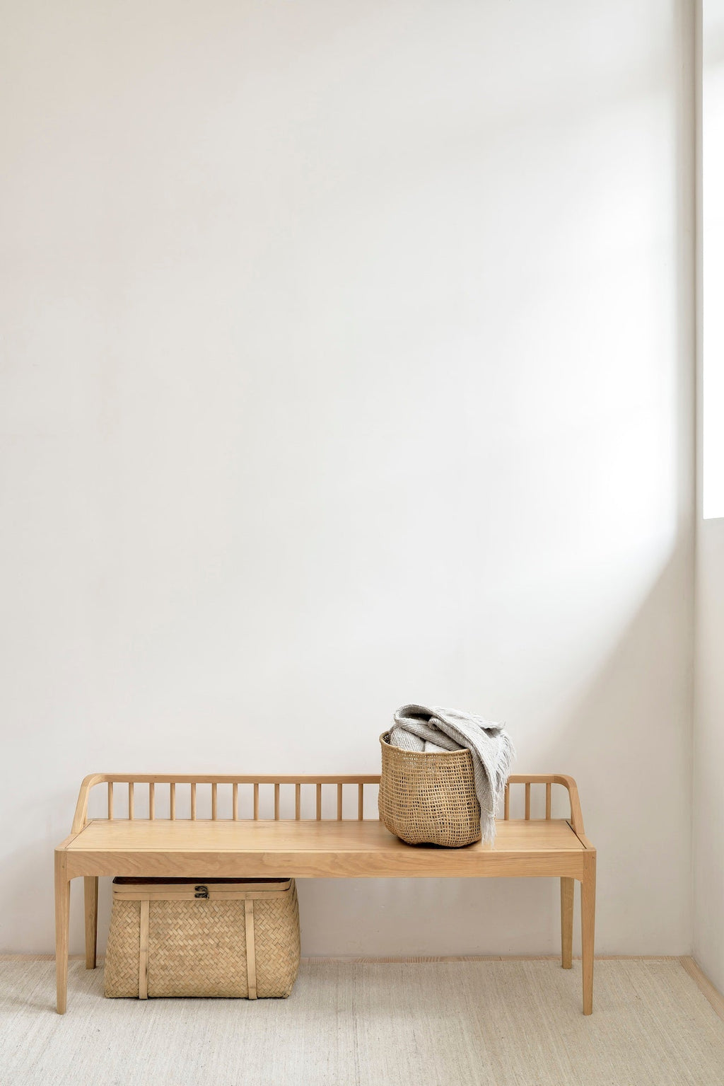 Spindle bench made of European white oak with low spoked back and spacious seat in coastal modern style