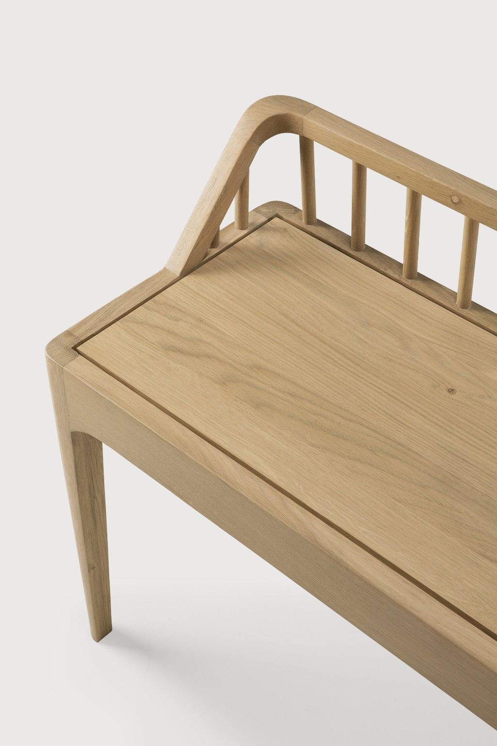 White oak spindle bench with low spoked back and spacious seat in coastal modern style