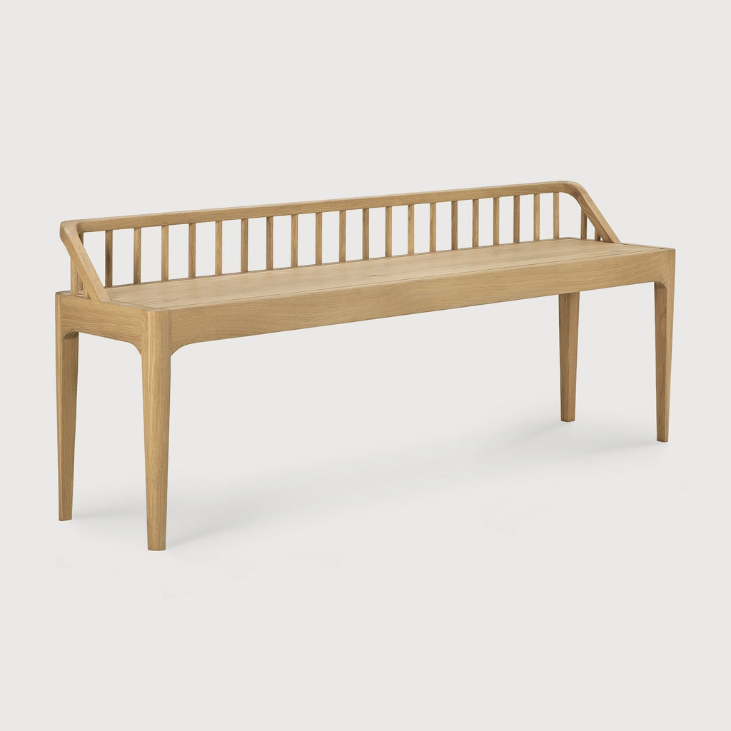 Spindle bench in white oak with low spoked back and spacious seat in modern coastal style