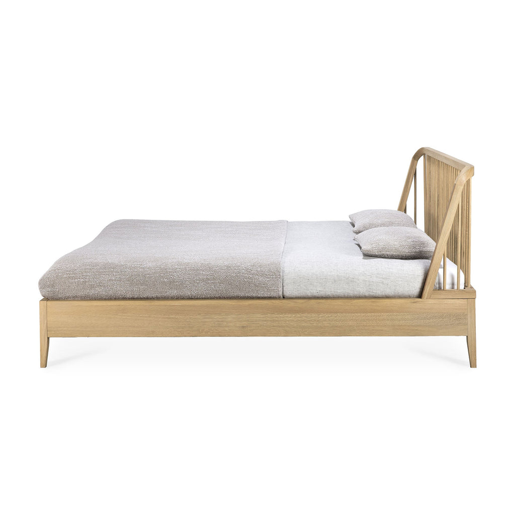 White oak spindle bed with classic headboard and curved edges in a coastal modern style