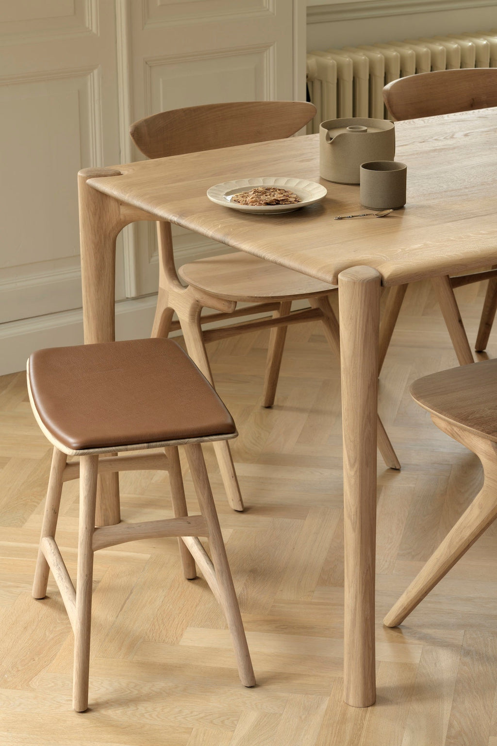 PI Dining Table in white oak with sculpted base and curved edges, modern and solid design