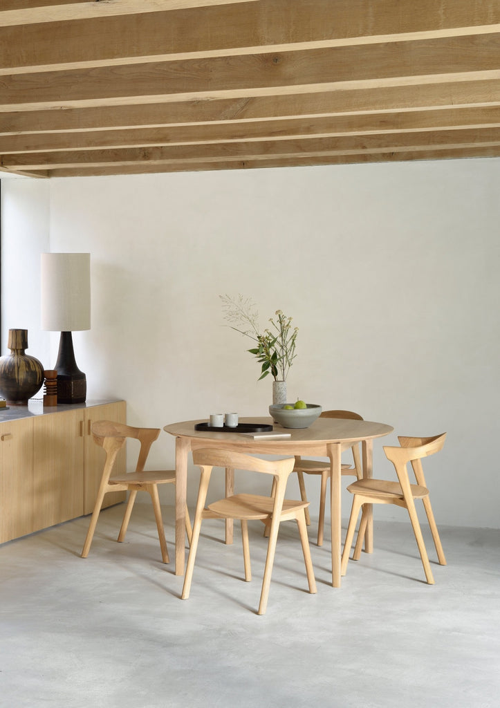 Oak Bok Dining Chairs around a round table in modern European dining room with high ceilings, exposed beams and plastered floors. - Saffron and Poe, Ethnicraft