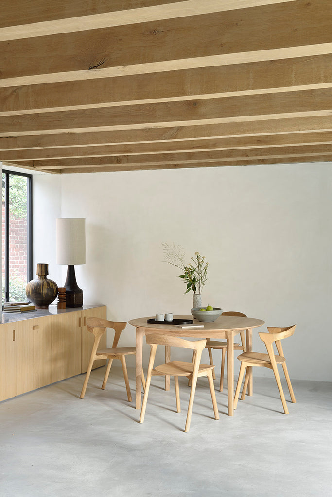Oak Bok Round Extendable Dining Table in dining room with Oak Bok Dining Chairs exposed beam ceiling, concrete floors, oak sideboard with floating table top and beautiful wood joinery. - Saffron and Poe, Ethnicraft