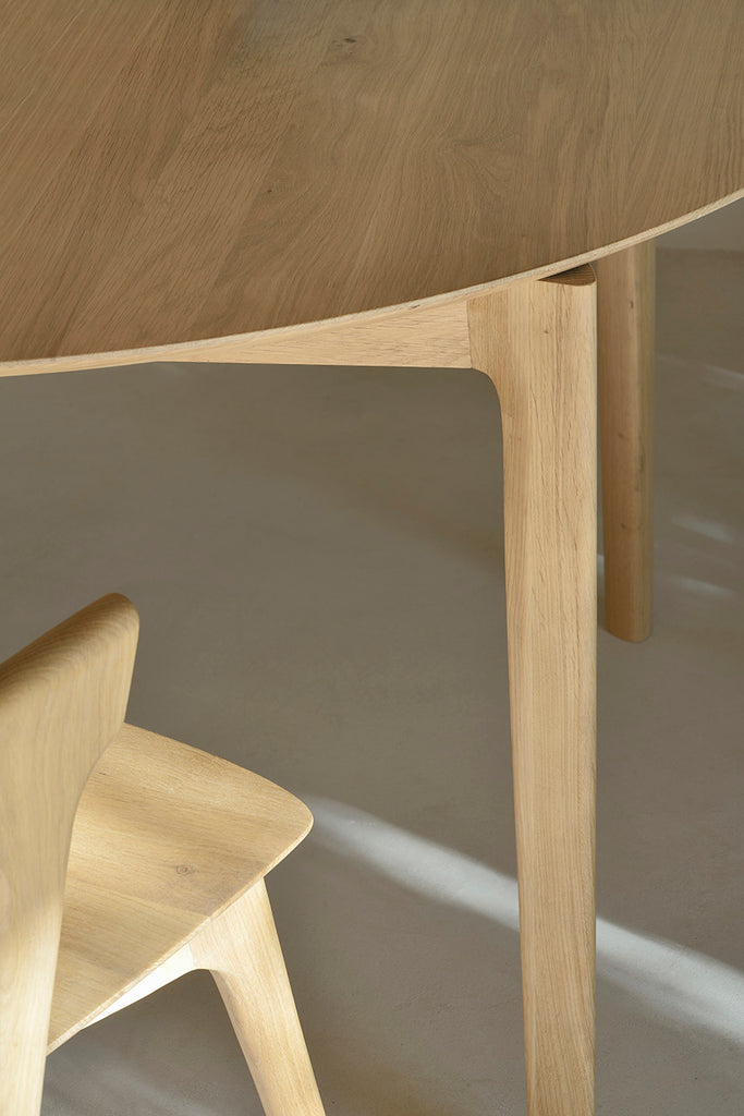 Oak Bok Round Extendable Dining Table close up with Oak Bok Dining Chair with white background. - Saffron and Poe, Ethnicraft