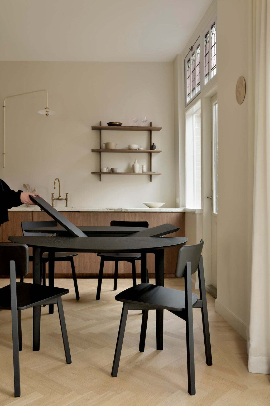 Bok Extendable Round Dining Table in black oak with floating top and sleek design