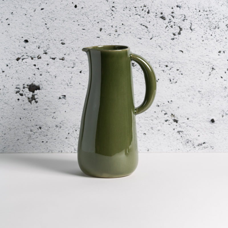 Handcrafted stoneware jug with rich green glaze, 50 oz capacity, handmade in Tunisia, food safe and dishwasher safe.