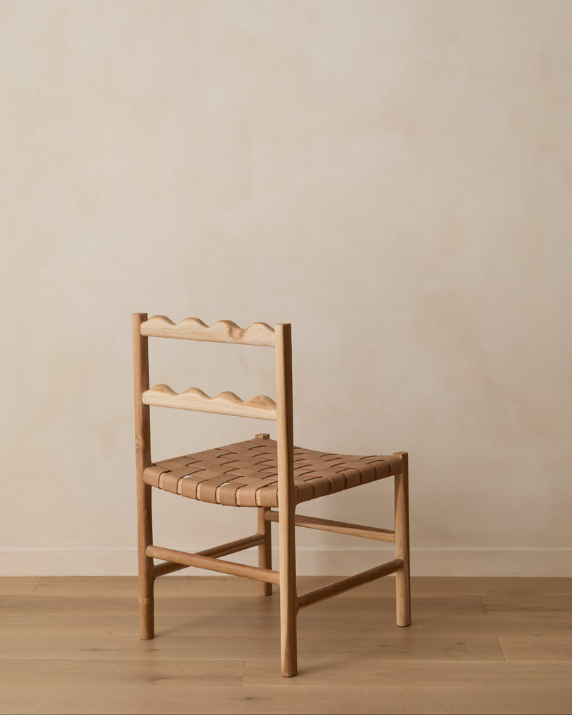 Aegean Scalloped Dining Chair on white oak floor against a beige lime washed wall. Saffron and Poe