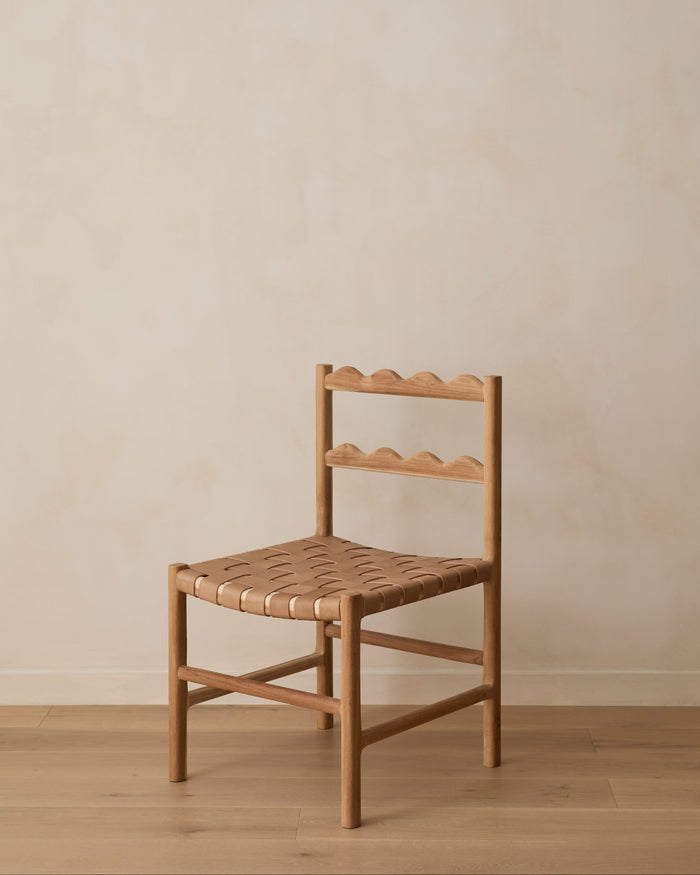 Aegean Scalloped Dining Chair on white oak floor against a beige lime washed wall. Saffron and Poe