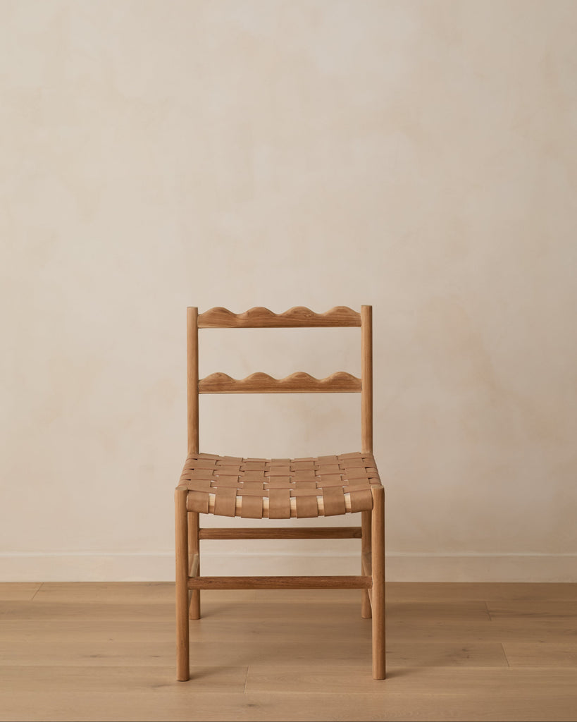 Aegean Scalloped Dining Chair on white oak floor against a beige lime washed wall. Saffron and Poe