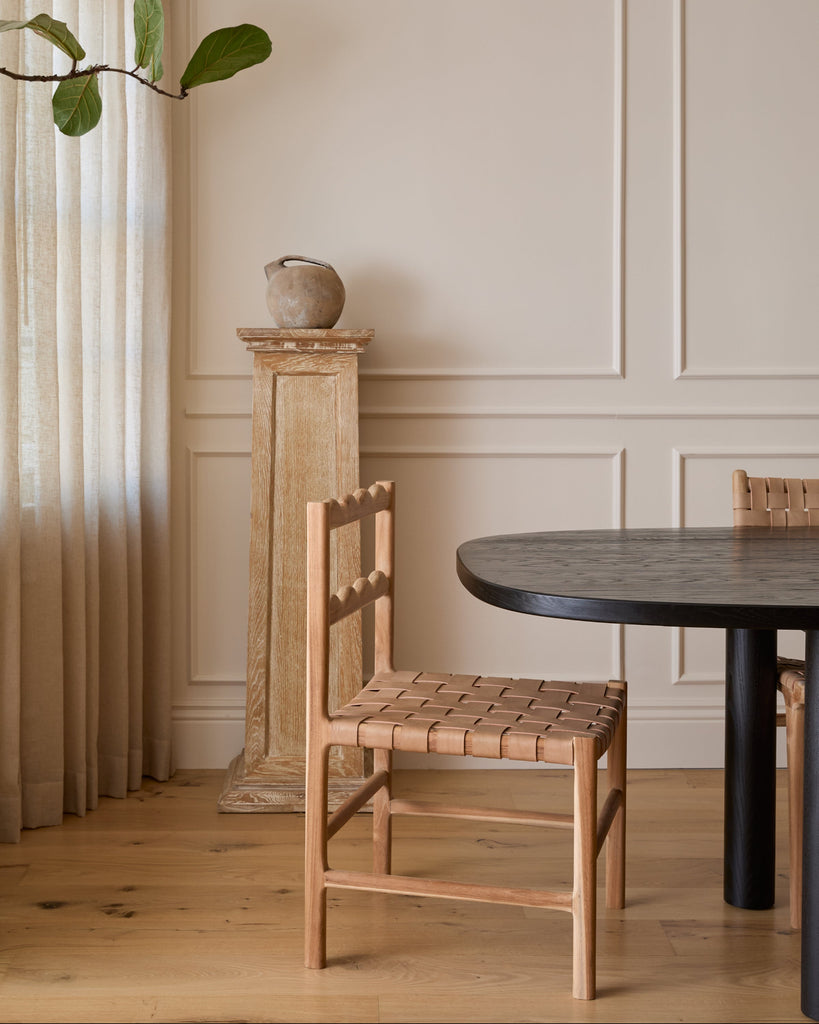 Aegean Scalloped Dining Chair in a dining room with a black table and white oak floor. Saffron and Poe