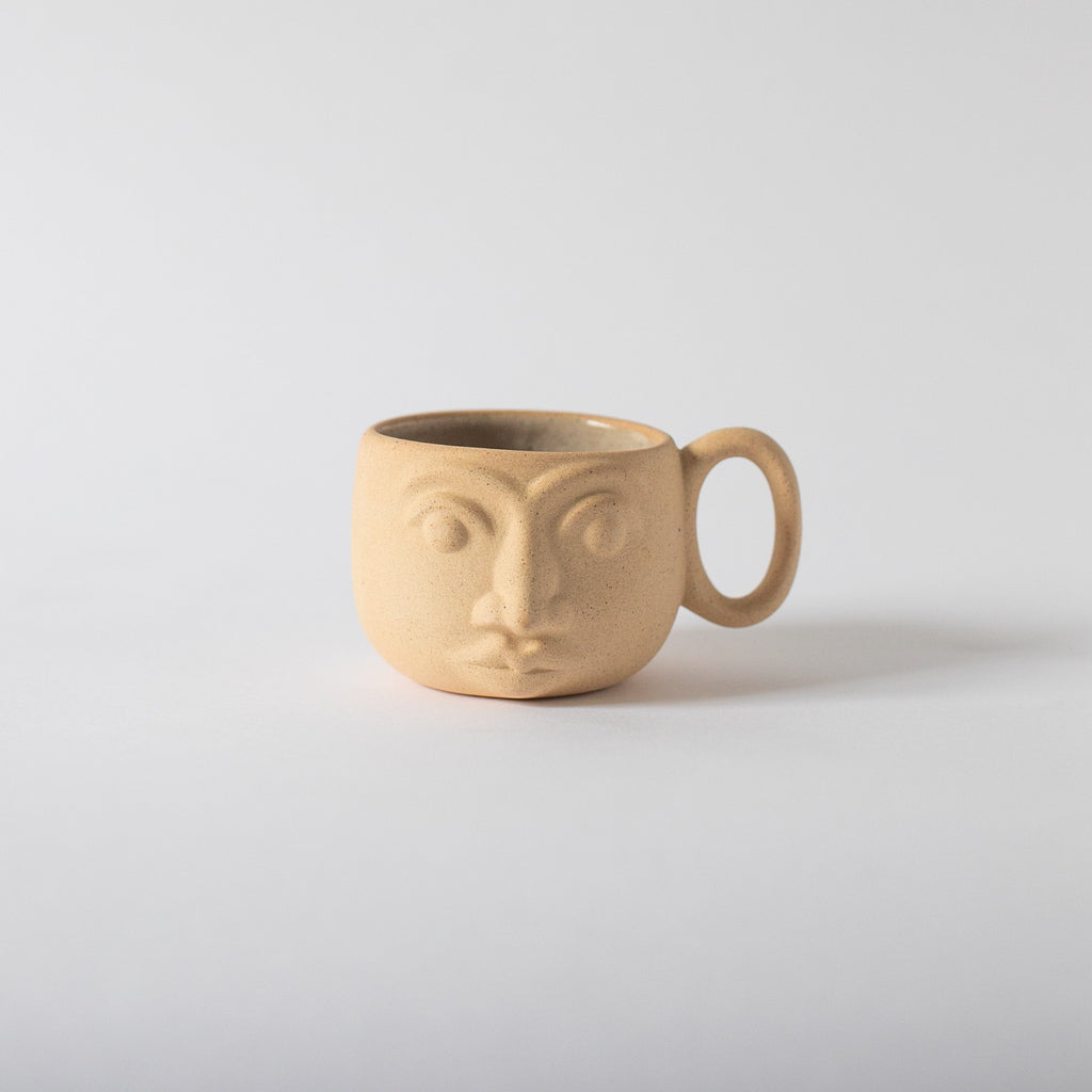 Handcrafted face mug made from high temperature ceramic and local clay with natural earth tones and interior glaze