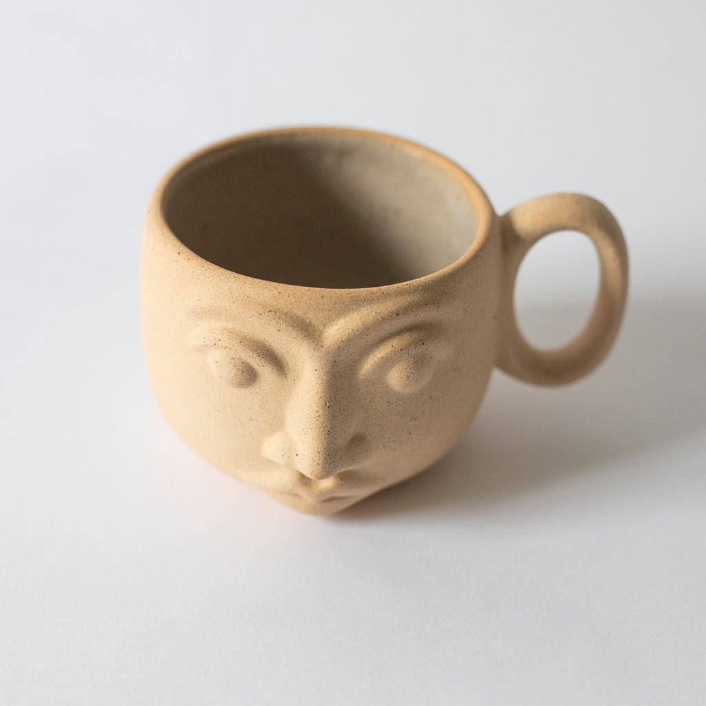 Handcrafted face mug made from high temperature ceramic and local clay with natural earth tone textures