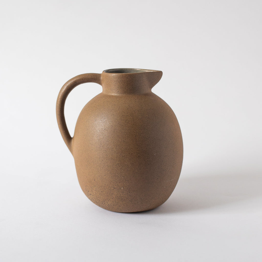 Handcrafted ceramic ball pitcher with natural earth tones and glazed interior