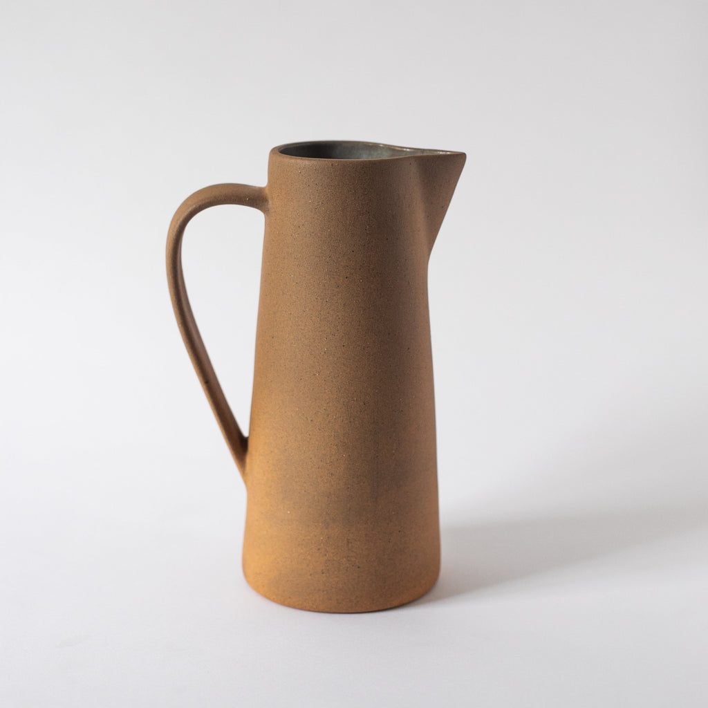 Handcrafted tall ceramic pitcher with earth tones and textured finish