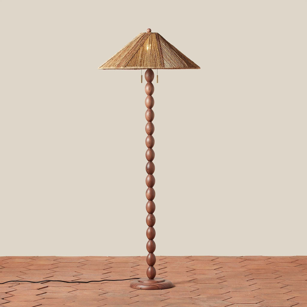 Alhambra Floor lamp with wooden base and straw-like shade on a beige background