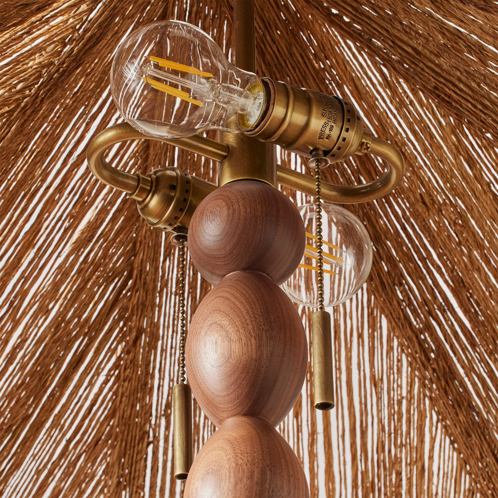 Alhambra Floor Lamp with wooden beaded body and brass accents against a wooden background