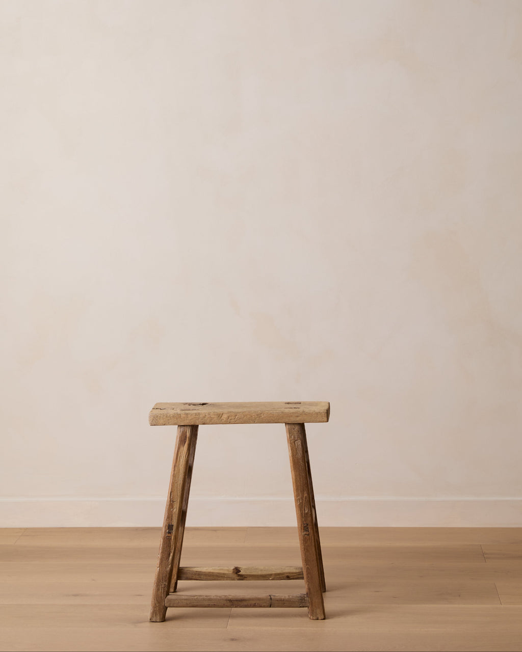 Antique elmwood stool handcrafted with mortise and tenon joinery, showcasing vintage patina and rustic character.