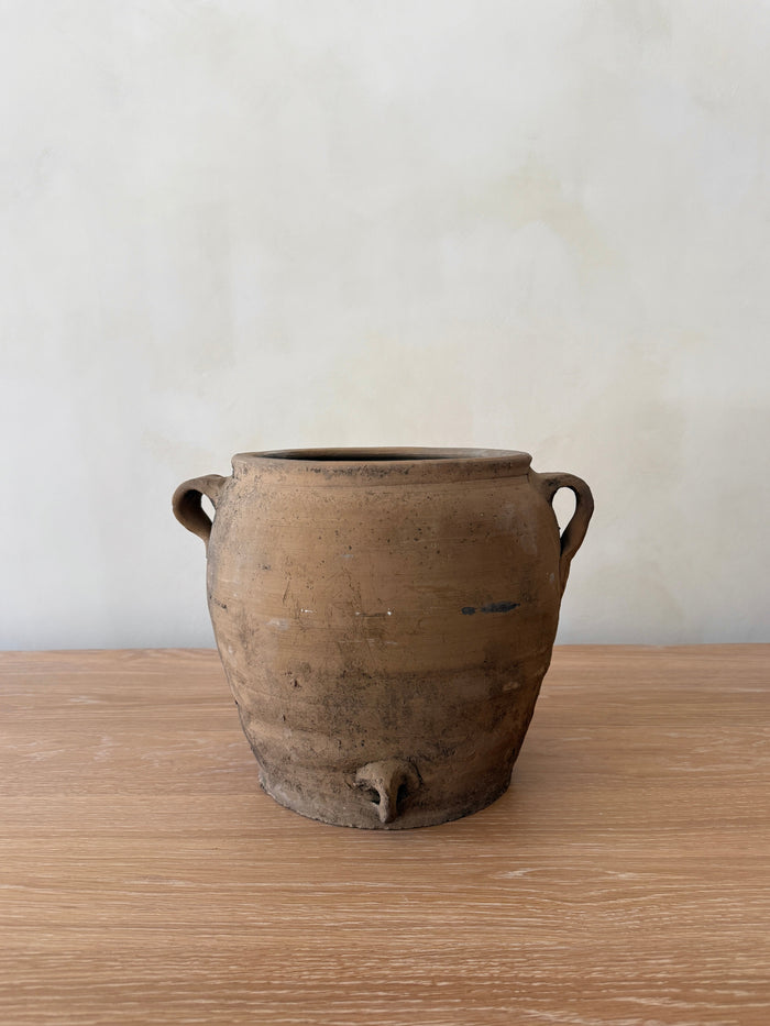 Umber Antique Clay Pot with handles on a wooden surface and white background. Saffron + Poe