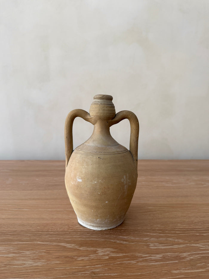 Antique Italian Vessel with handles on a wooden surface against a plain background - Saffron + Poe