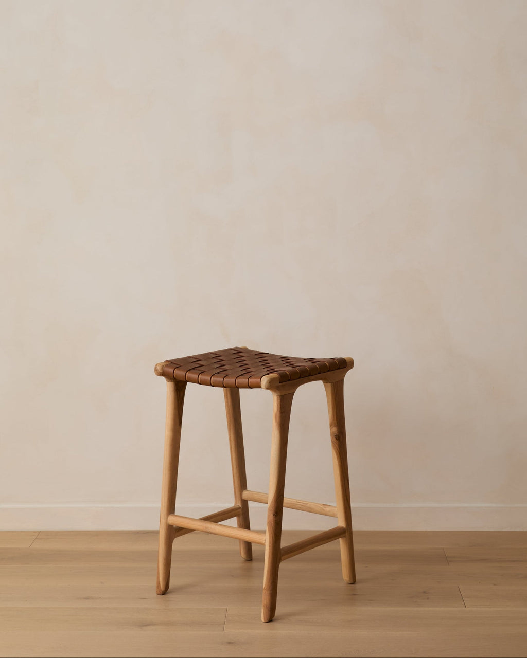 Backless woven leather counter stool in saddle color with teak frame, handcrafted and second quality.