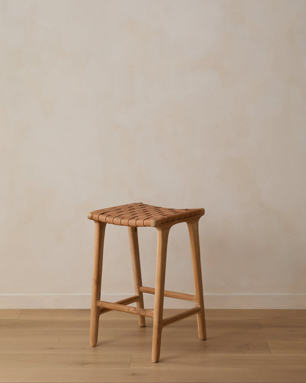 Backless woven leather counter stool in beige with carved teak frame, handcrafted in Bali, second quality with natural leather and wood variations