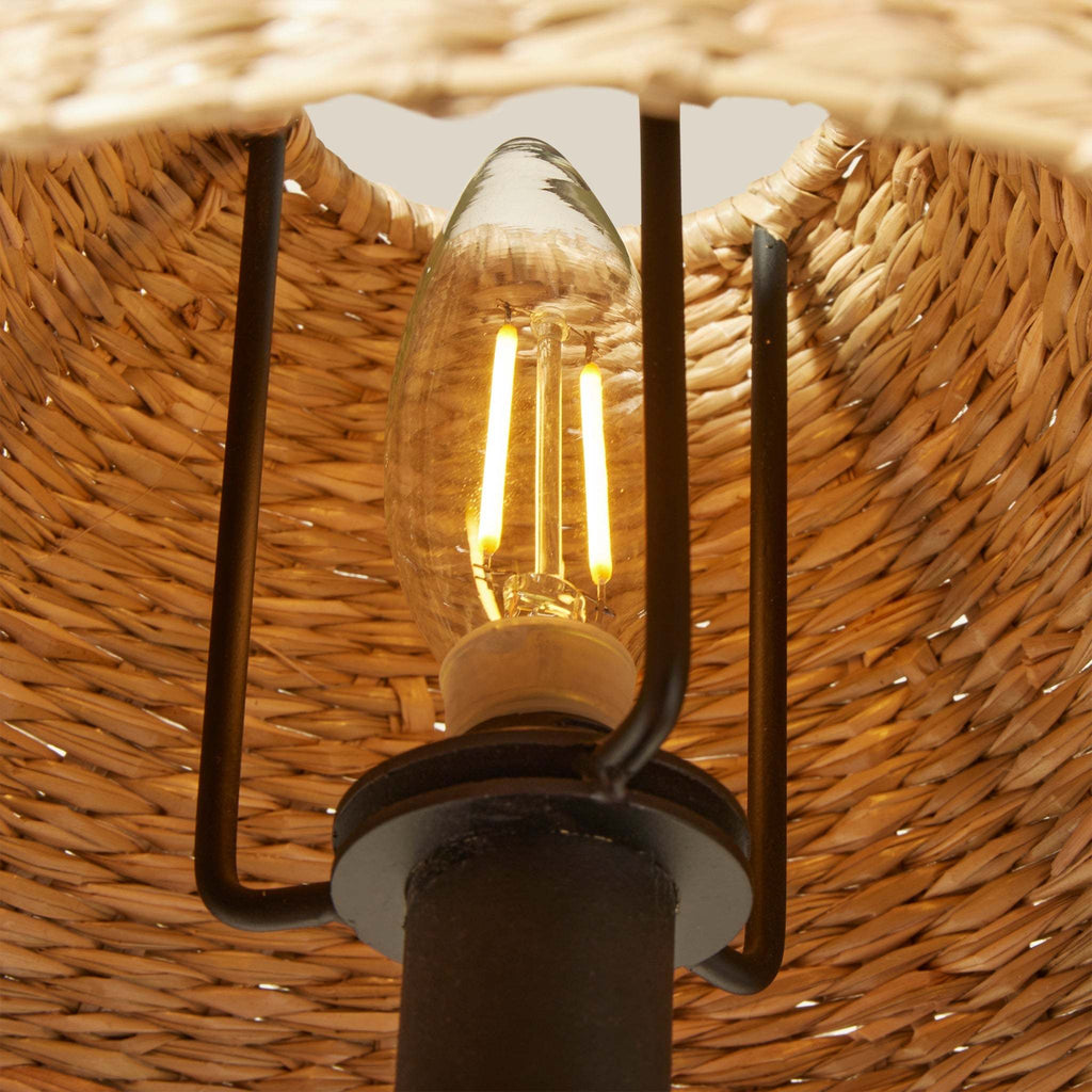 Light bulb inside a woven Bainbridge chandelier lampshade with a blurred background