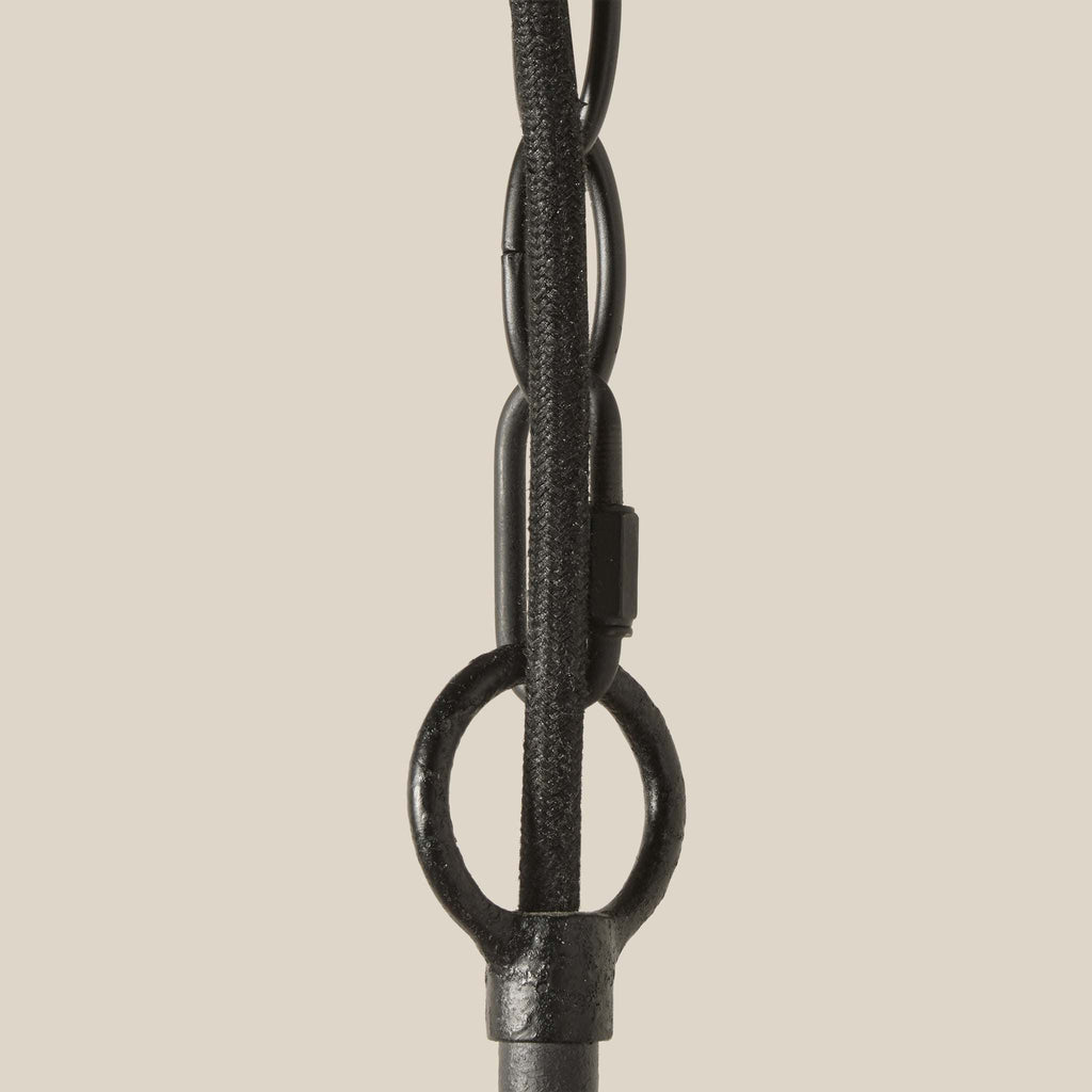 Close-up of a black metal chain on a beige background