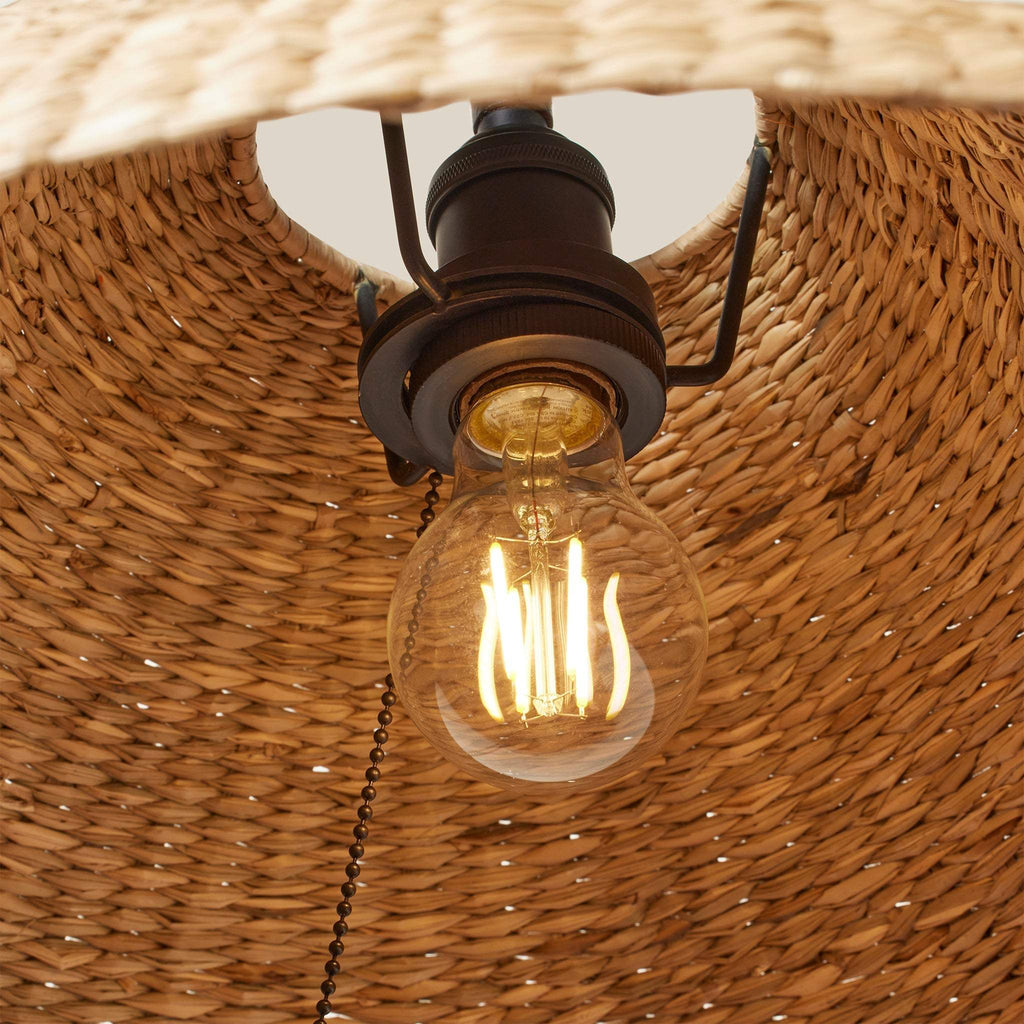 Vintage-style light bulb inside a wicker lampshade