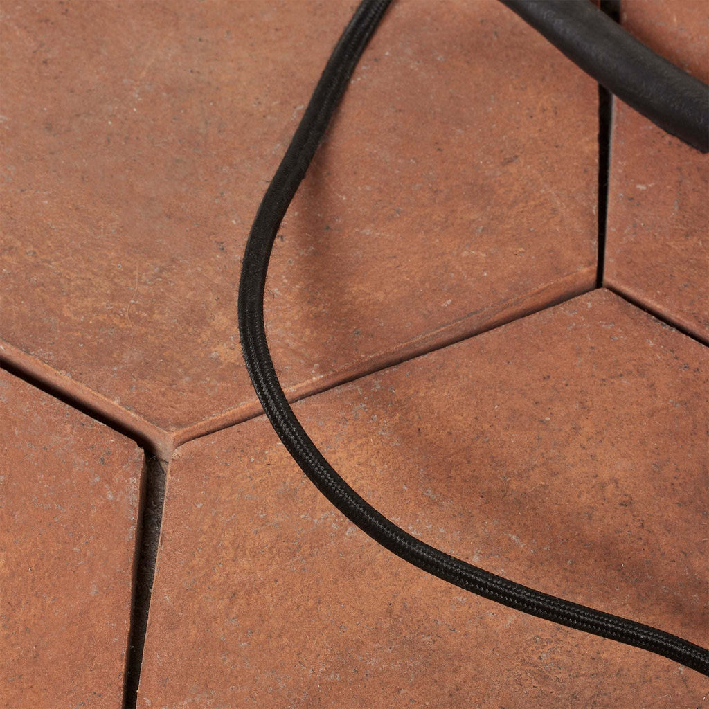 Close-up of a black cable of Bainbridge floor lamp on a brown tiled floor