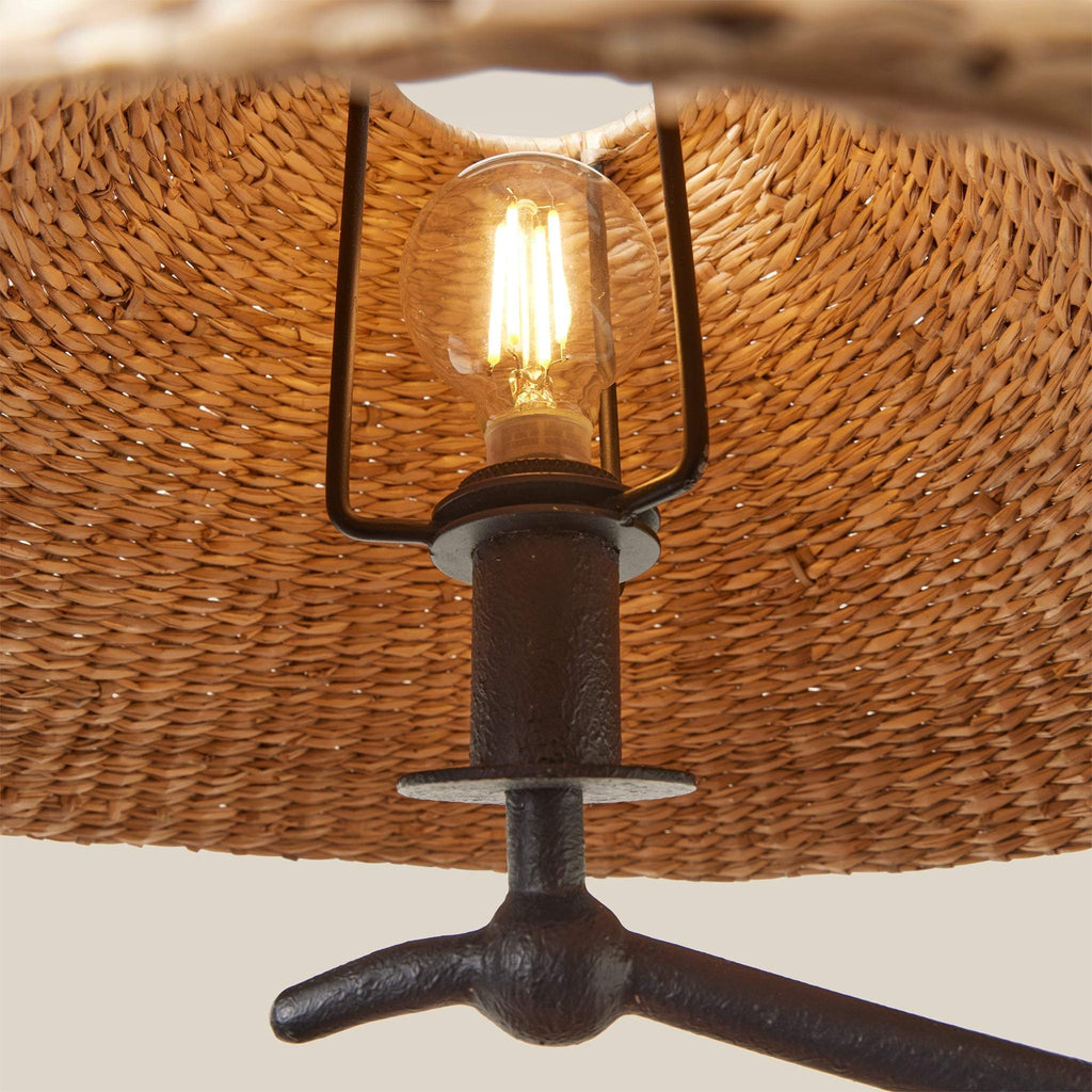 Vintage-style light bulb in a rustic metal holder against a woven background