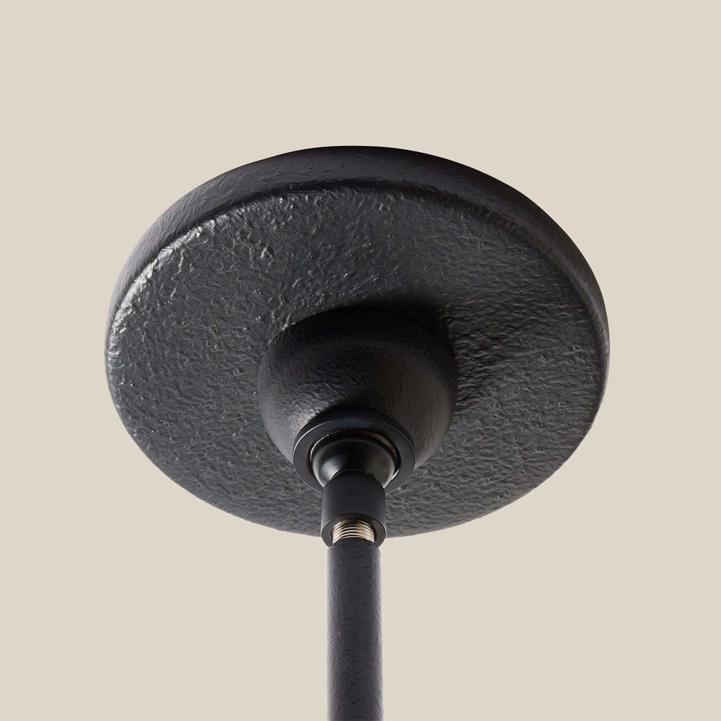 Close-up of a black ceiling light fixture on a beige background