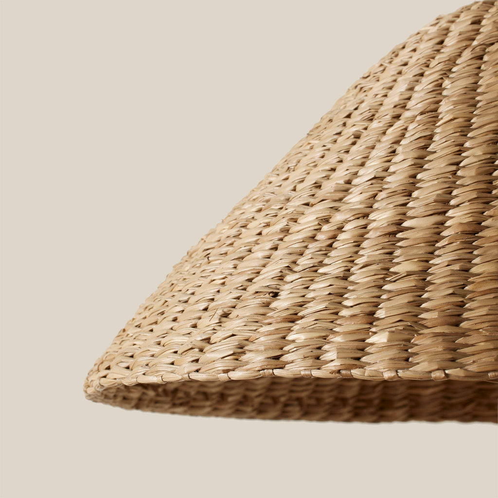 Bainbridge Oversized Swing Arm Sconce close-up of a woven seagrass shade on a beige background